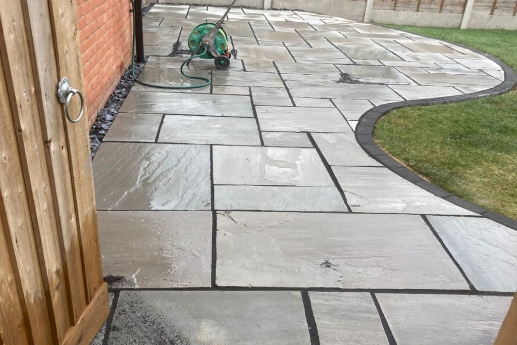 Grey Sandstone Slabbed Patio with Black Grout and French Gravel Drains in Hamstead (4)